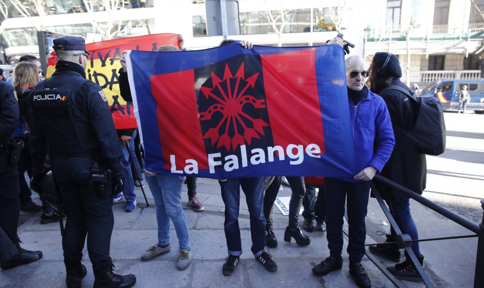 Un hombre sujeta una bandera de La Falange, en la concentración en contra de lo procesados por el juicio del Procés en el Tribunal Supremo. Eduardo Parra Europa Press
