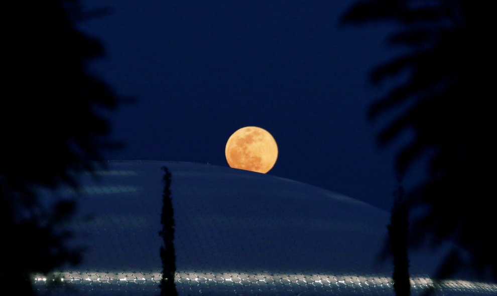 La luna llena se levanta detrás de la biblioteca de la Universidad de Chipre en Nicosia | REUTERS/ Yiannis Kourtoglou