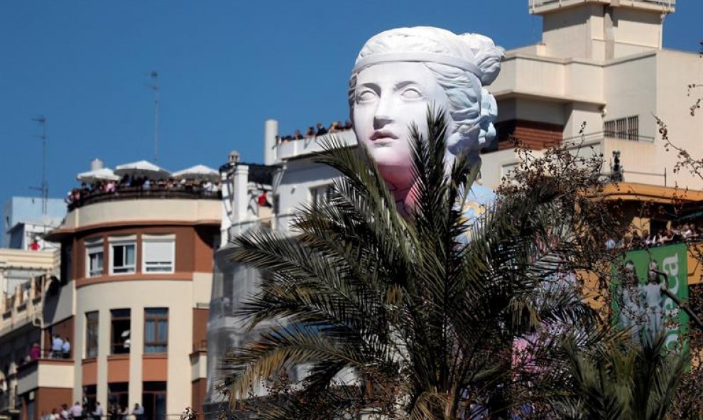 Detalle del remate principal de la falla municipal que asoma entre árboles y edificios cuando ya están plantados los casi 770 monumentos falleros desperdigados por la ciudad. EFE/ Kai Försterling