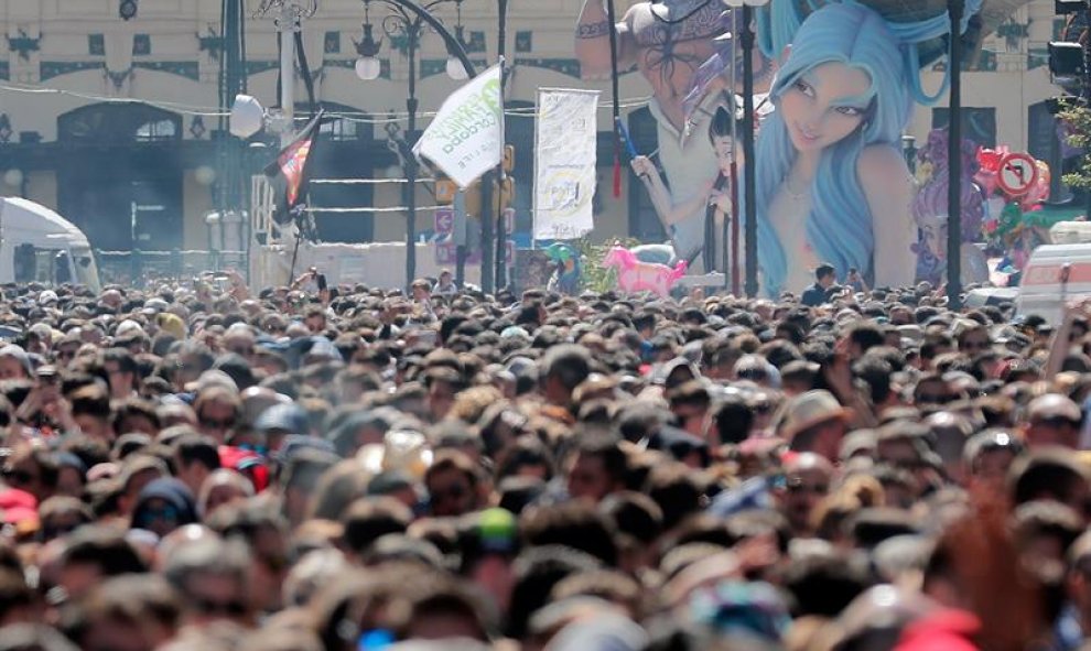 Detalle del remate principal de una falla que asoma por encima del público asistente a la mascletá que con un atronador bombardeo inicial, seguida de ritmo, potencia y color ha permitido a la pirotécnica María José Lora Zamorano "quitarse la espinita" del