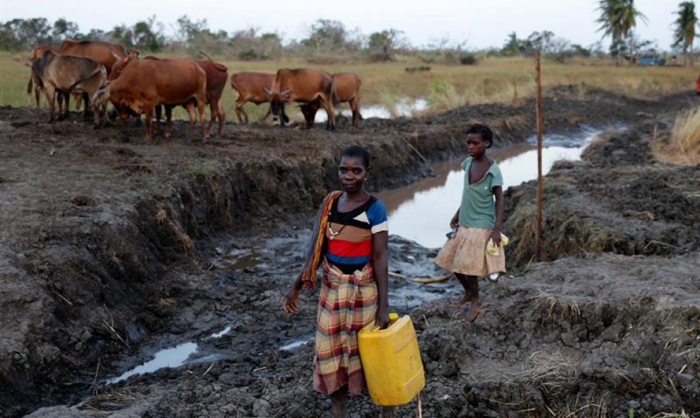 Varias mujeres desplazadas tras el paso del ciclón Idai recogen agua en Sofala. EFE