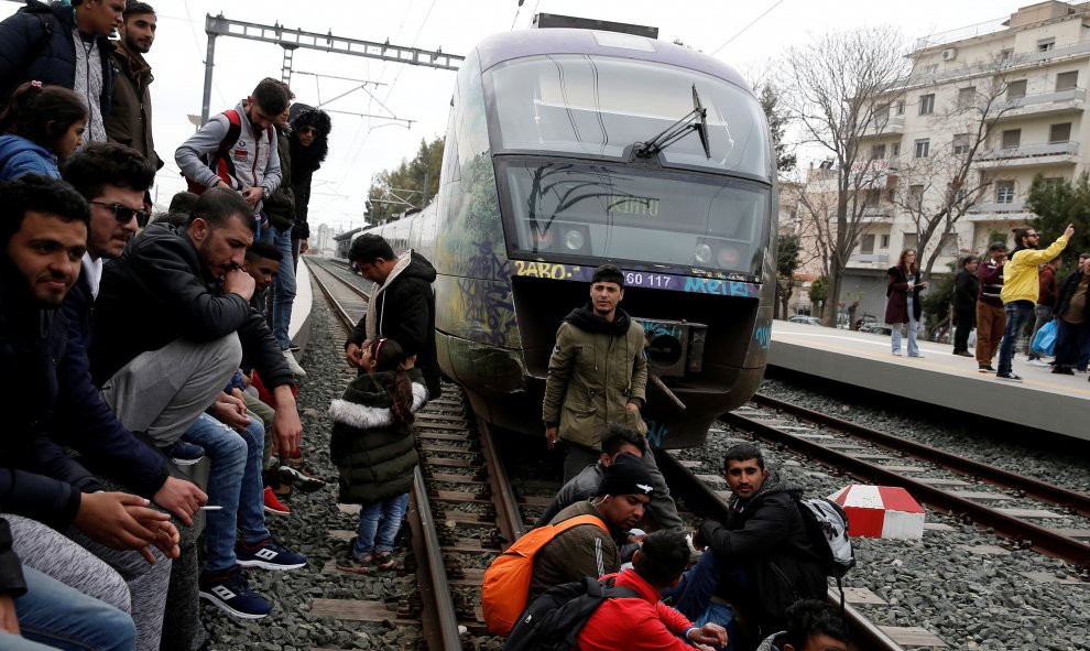 Personas migrantes sentadas en las vías del tren este 5 de abril durante una protesta en Atenas. REUTERS/Costas Baltas