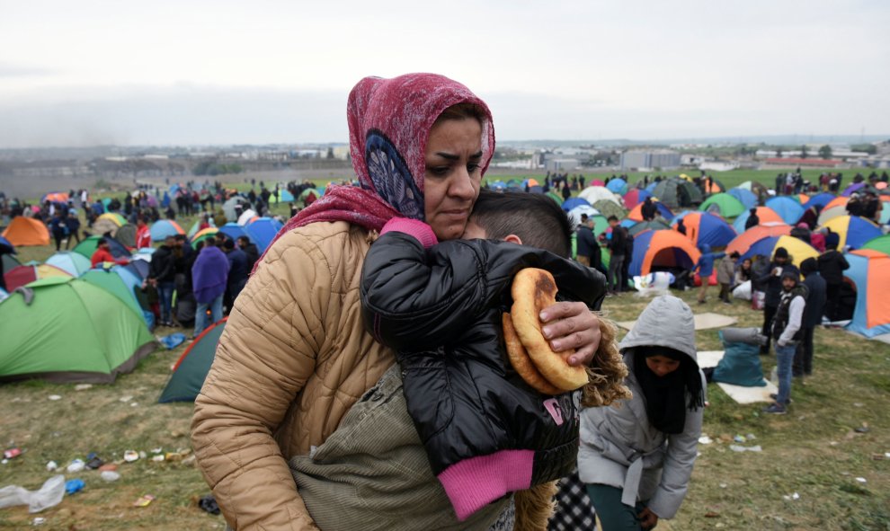 Una mujer sostiene a su hijo en el campamento de Diavata, en el norte de Grecia. REUTERS/Alexandros Avramidis