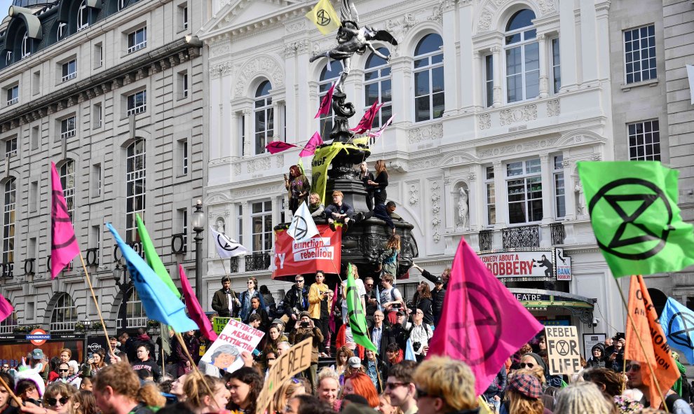 15/04/2019 - Los activistas del grupo de Extinción Rebelión ondean banderas mientras en la Fuente Conmemorativa de Shaftesbury durante una manifestación en Piccadilly Circus en Londres | AFP/ Daniel Leal-Oliva
