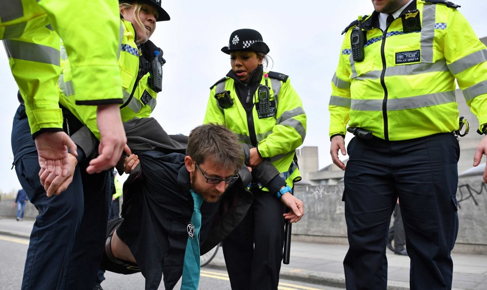 16/04/2019 - Policías británicos llevan a un activista mientras retiran a los manifestantes de su bloqueo del puente de Waterloo | AFP/ Ben Stansall