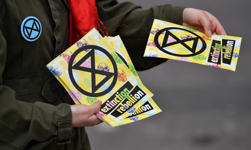 16/04/2019 - Un activista reparte folletos del grupo Extinción Rebelión en el segundo día de una protesta ambiental del grupo de Extinción Rebelión, cerca del Puente de Waterloo en Londres | AFP/ Ben Stansall