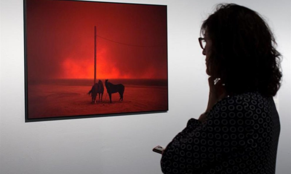 Una visitante observa una foto que forman parte de la exposición Las historias que importan, que muestra las imágenes ganadoras. EFE