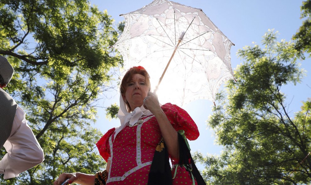 15/5/2019 Una mujer vestida de chulapa se protege del sol con un paraguas en los alrededores de la Ermita del Santo.- EFE