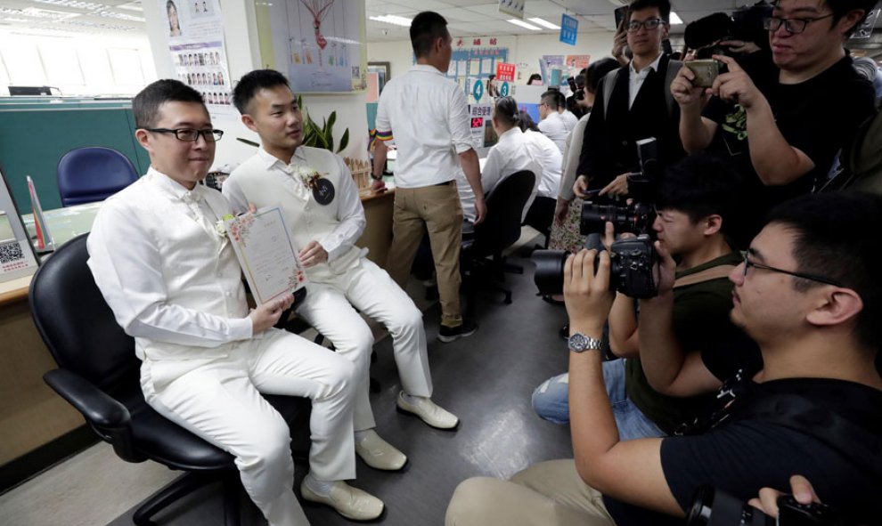 23/05/2019.- Una pareja de hombres posa para los medios durante el primer día del registro civil para matrimonios del mismo sexo este jueves, en Taipei (Taiwán). Taiwán se convirtió en el primer país asiático en legalizar el matrimonio entre personas del