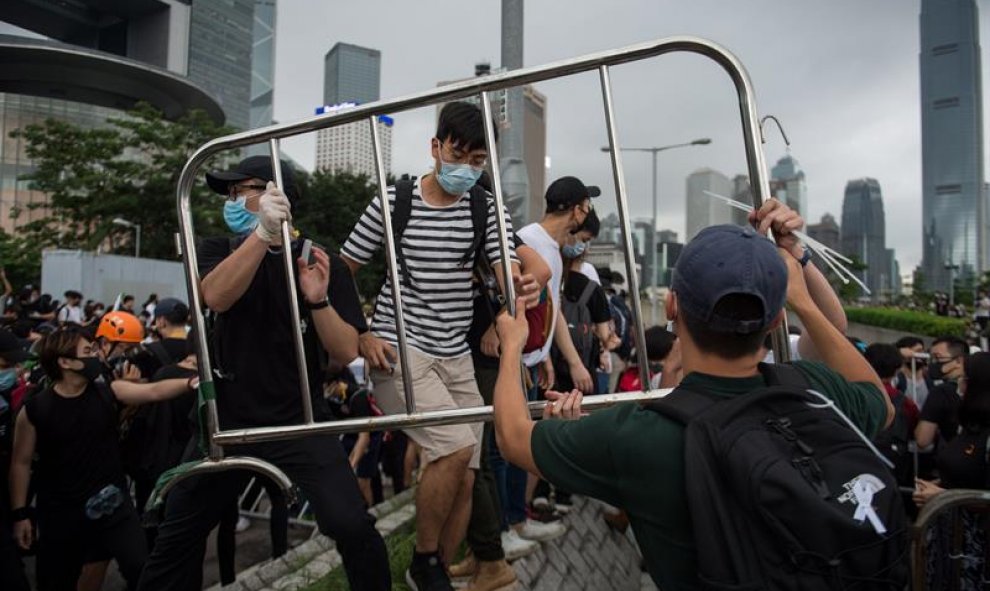 Manifestantes usan barreras para construir una barricada en una calle principal durante un mitin contra las enmiendas a un proyecto de ley de extradición cerca del Consejo Legislativo en Hong Kong. EFE / Jerome Favre