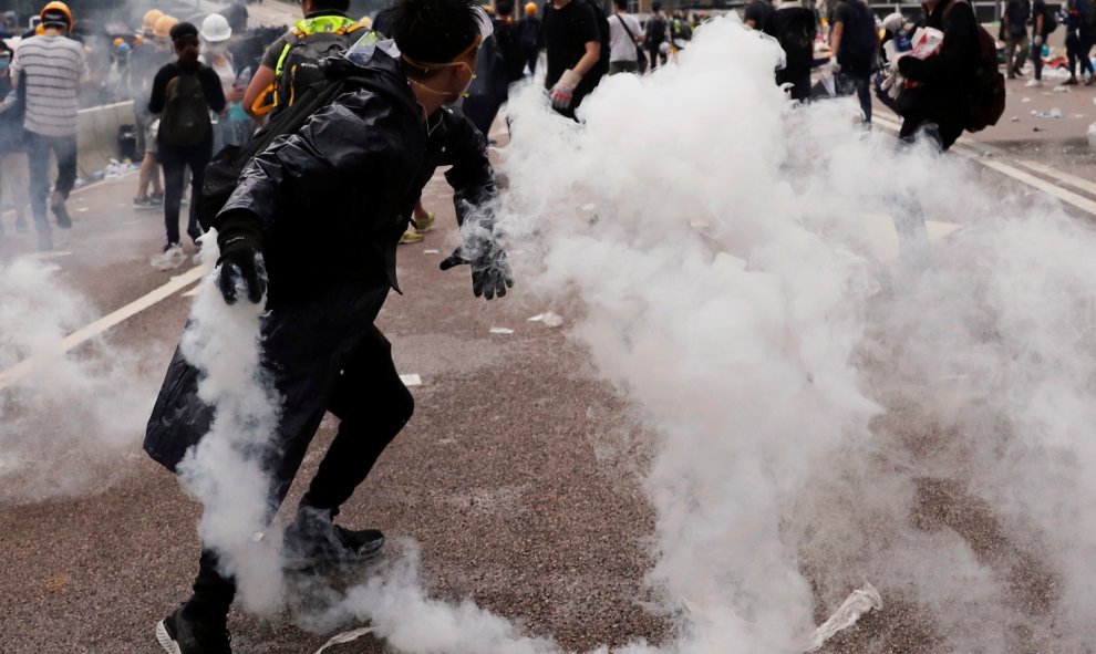 Un manifestante lanza un bote de gas lacrimógeno durante una manifestación contra un proyecto de ley de extradición en Hong Kong. Reuters
