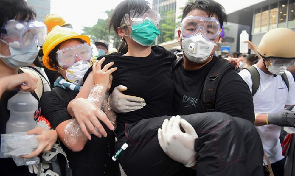Un manifestante recibe ayuda tras resultar afectado por el gas lacrimógeno. EFE