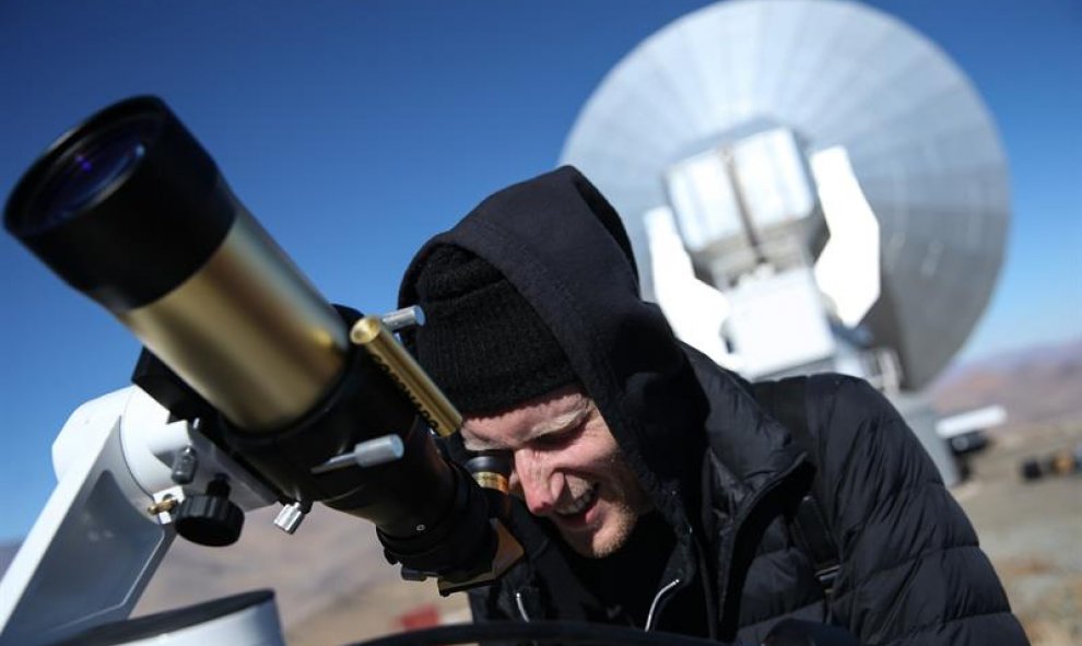 Un hombre observa el sol a través de un telescopio horas antes de que comience el eclipse solar total, este martes en el Observatorio de La Silla, situado en la región de Coquimbo (Chile). EFE