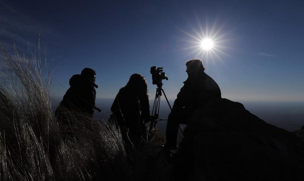 Espectadores al filo de la montaña, observan el sol durante el eclipse solar total en la ciudad de Merlo, San Luis (Argentina). EFE