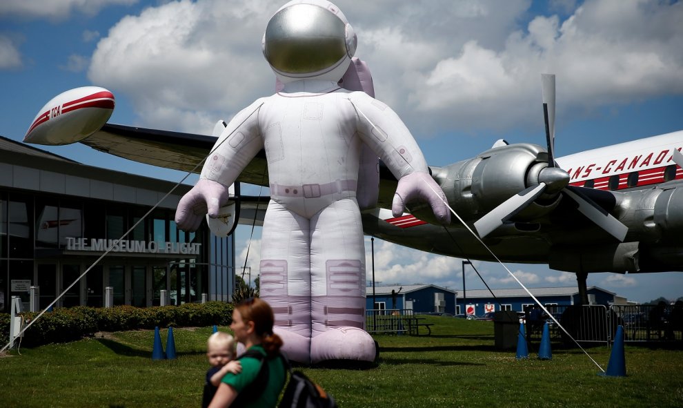 Los visitantes caminan junto a un gran astronauta inflable en el aniversario del lanzamiento de la misión Apollo 11 fuera del Museo de Vuelo en Seattle. Reuters