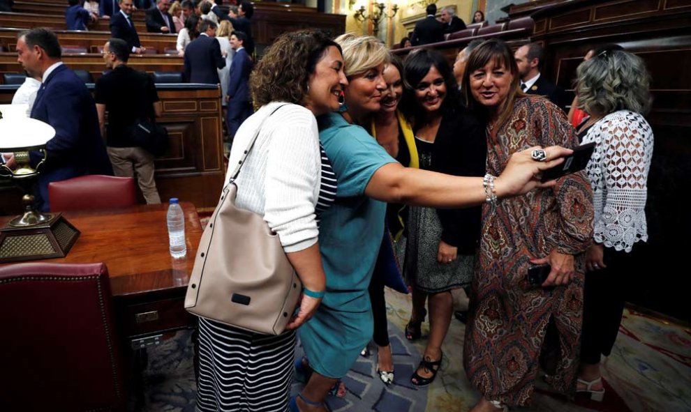 No todo va a ser política, también hay tiempo para otras cosas. Varias diputadas se fotografían a su llegada al hemiciclo del Congreso en la primera jornada del debate de investidura. (EMILIO NARANJO | EFE)