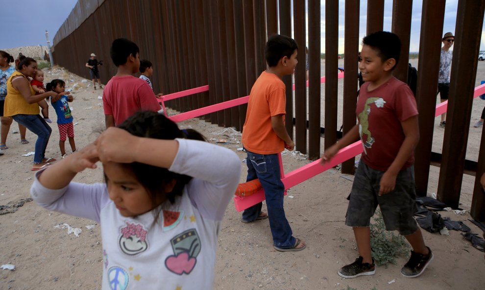 Los niños mexicanos se divierten en la frontera mientras juegan con niños norteamericanos, situados al otro lado de la valla. LUIS TORRES (AFP).