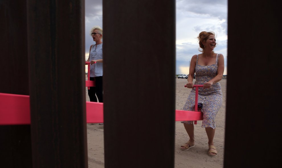 Varios adultos se han acercado a probar el balancín situado en la frontera entre México y Estados Unidos. LUIS TORRES (AFP)