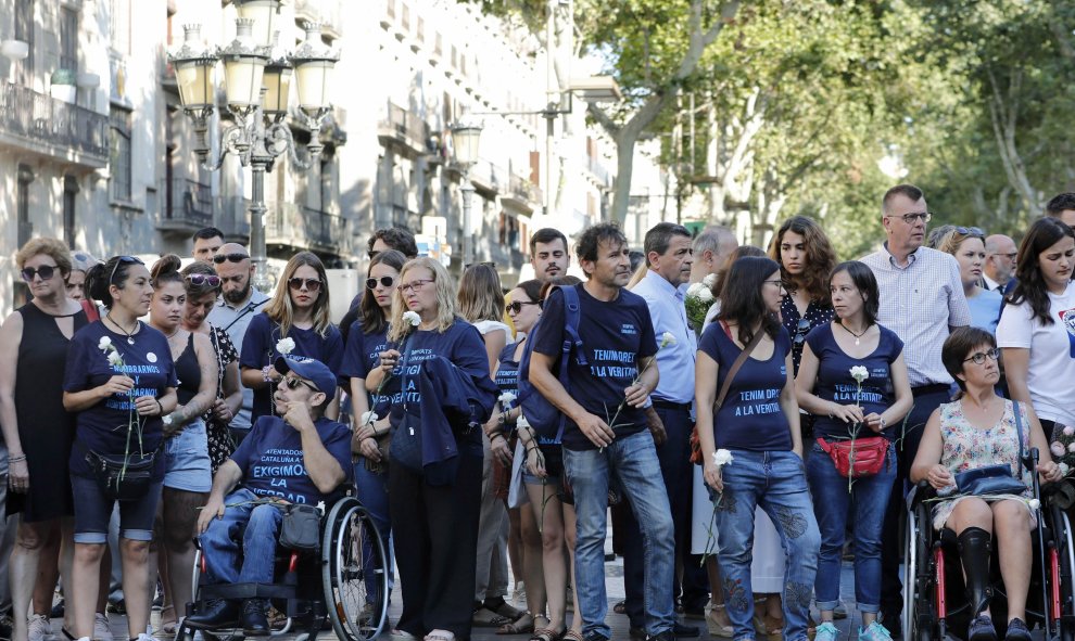 Familiares de las víctimas y afectados por del atentado terrorista del 17A en Barcelona llevan camisetas reivindicativas durante el acto institucional celebrado esta mañana las Ramblas para conmemorar el segundo aniversario del suceso | EFE