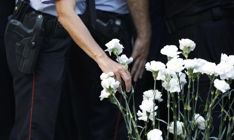 Miembros del cuerpo de los Mossos d,Esquadra depositan claveles blancos, durante el acto institucional celebrado este sábado en conmemoración del segundo aniversario del atentado terrorista del 17A en las Ramblas de Barcelona | EFE