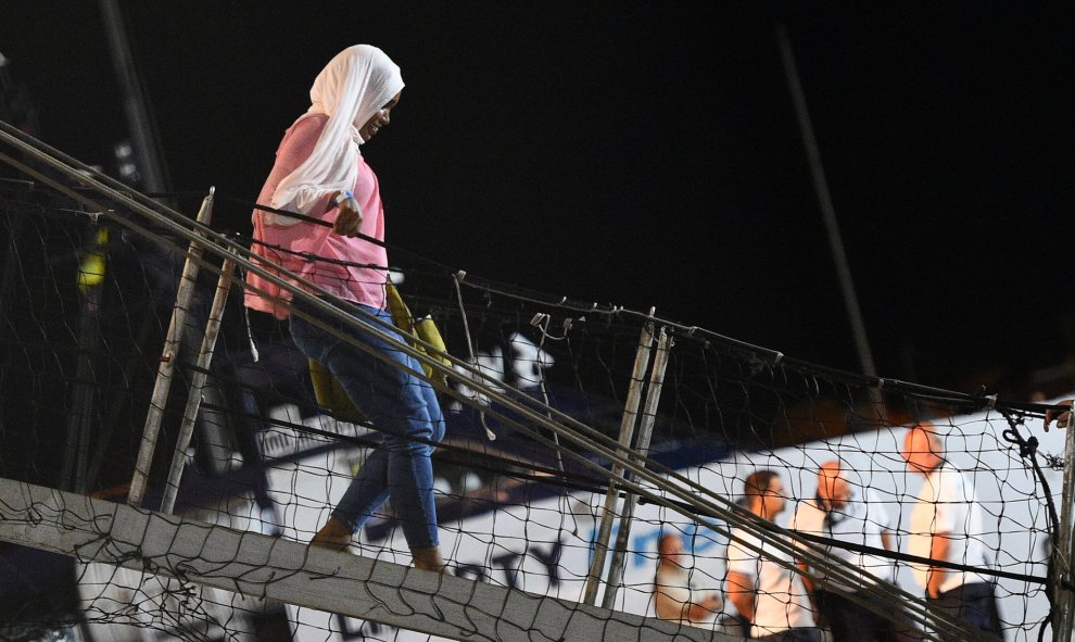 Una de los 83 migrantes que quedaban a bordo del barco Open Arms, desembarcando en la isla de Lampedusa. REUTERS/Guglielmo Mangiapane