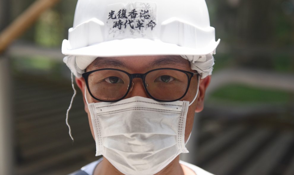 Un estudiante usa un casco con escritos que dicen 'Liberate Hong Kong, revolución de nuestro tiempo' mientras estudiantes de City University y Baptist University forman una cadena humana en Hong Kong, China, el 09 de septiembre de 2019. EFE/EPA/MIGUEL CAN