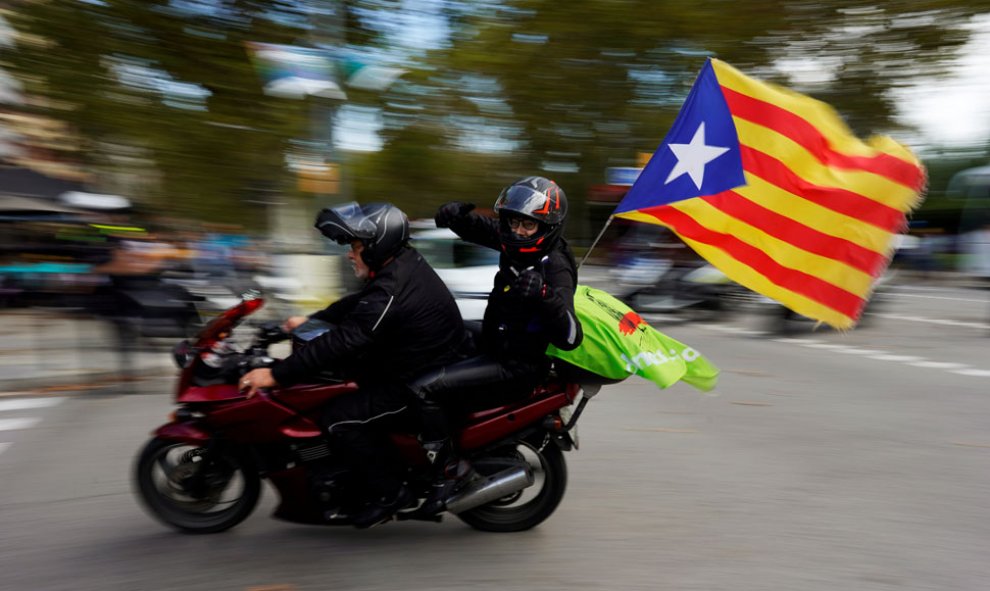 Una pareja de motoristas, con una estelada, durante la celebración de la Diada en Barcelona. / REUTERS