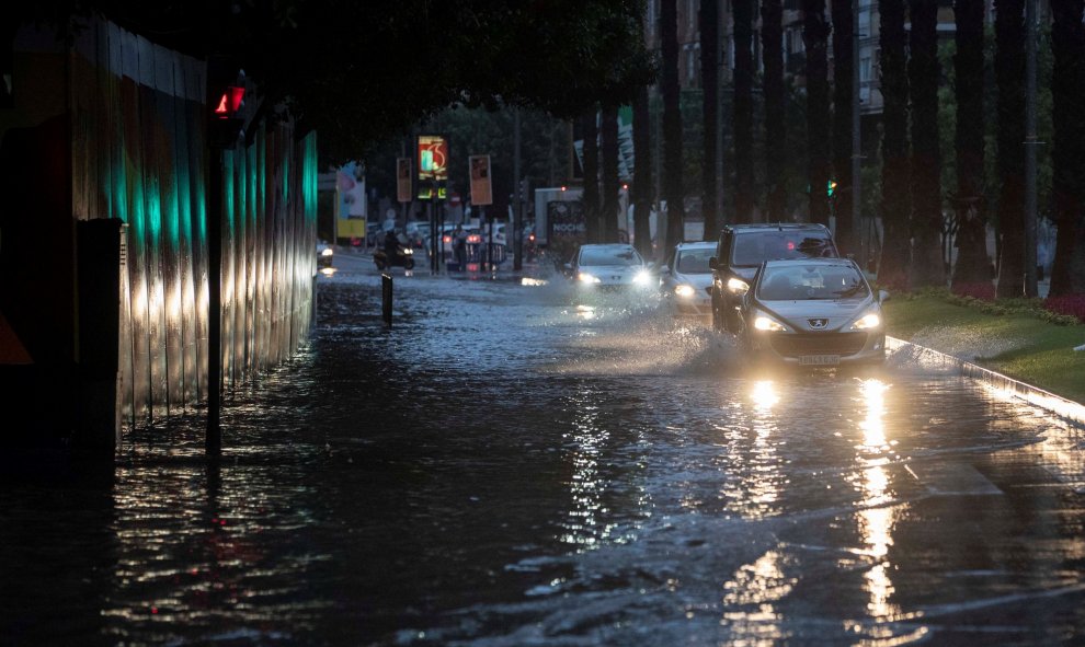 Varios coches circulan esta mañana por la calle Plano de San Francisco de Murcia, inundada tras las intensas lluvias caídas esta madrugada. EFE/Marcial Guillén