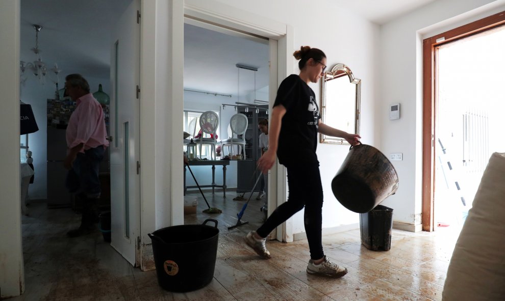 Una mujer limpia una casa después de las inundaciones causadas por lluvias torrenciales en San Javier.-REUTERS / SERGIO PÉREZ