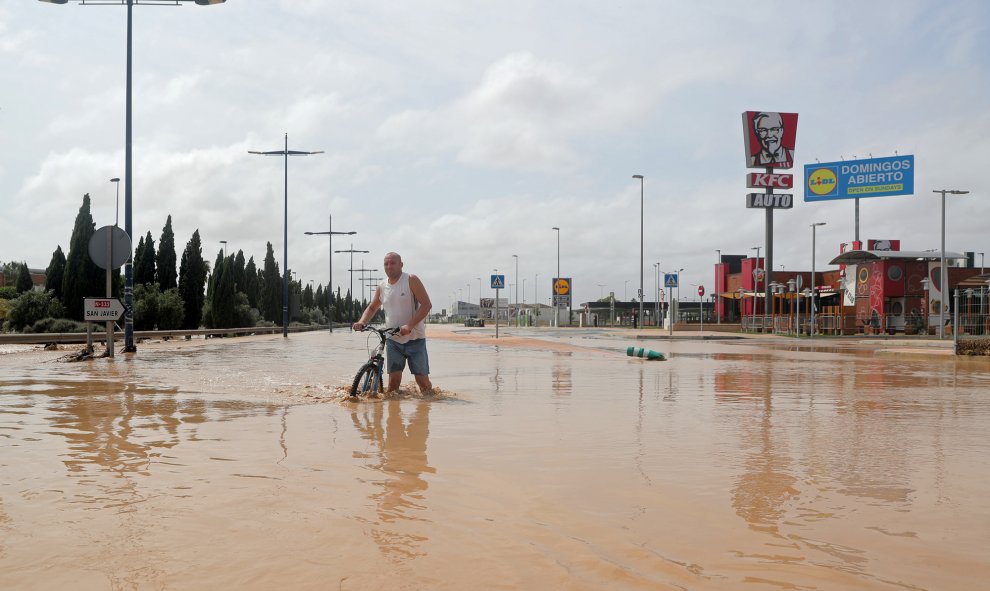 Un hombre camina por una calle inundada tras de fuertes lluvias por la gota fría en San Javier, Murcia.- REUTERS / SERGIO PÉREZ