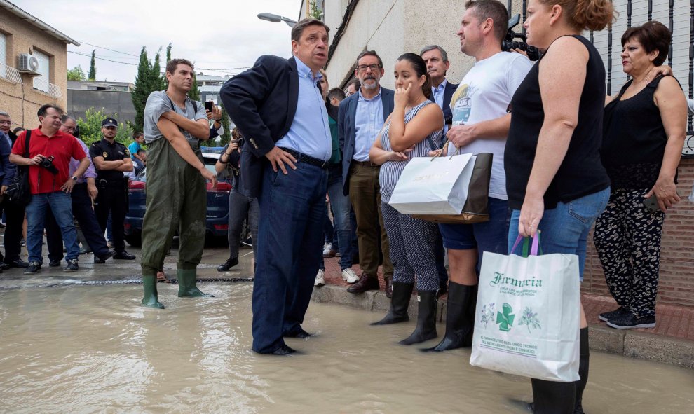 El ministro de Agricultura en funciones, Luis Planas (c), este sábado durante la visita al bario de la huerta de abajo de Molina de Segura, afectada por el desbordamiento del río Segura. EFE/Marcial Guillén