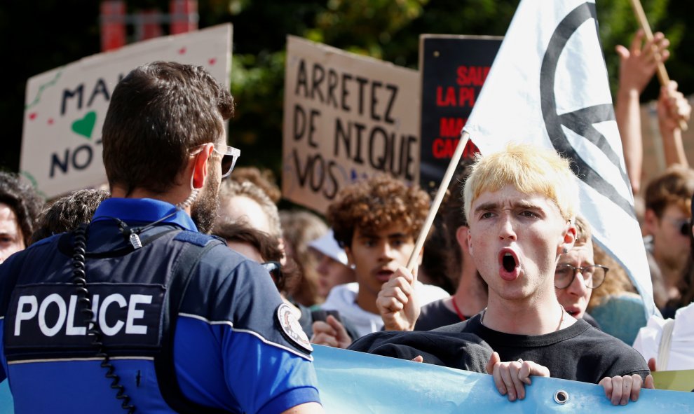 Un activista de la Rebelión de la Extinción grita consignas frente a un oficial de policía durante una marcha de demostración proclima en Lausana, Suiza REUTERS / Denis Balibouse