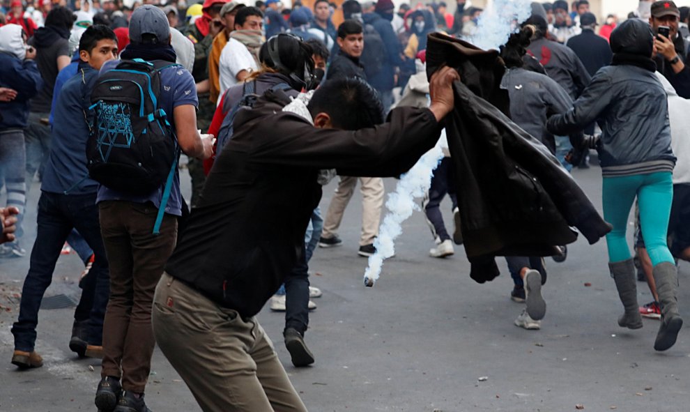 Los manifestantes corren y se cubren durante una protesta. REUTERS / Carlos Garcia Rawlins