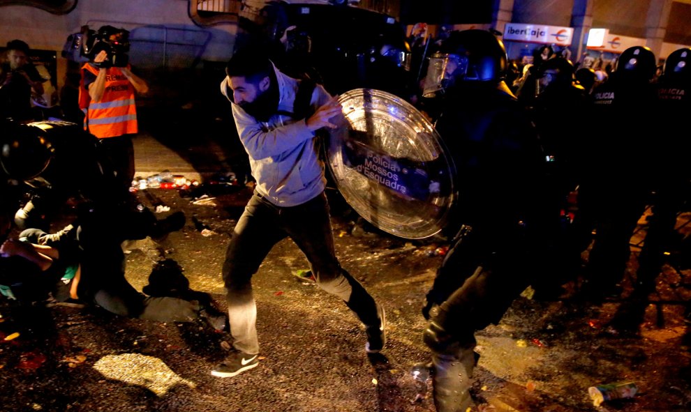 Un hombre forcejea con un agente de los Mossos durante las protestas por el centro de Barcelona. /REUTERS