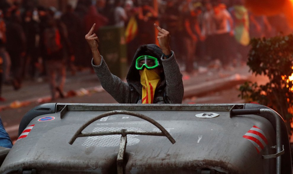Manifestante independentista hace frente a las fuentes del orden. / Reuters