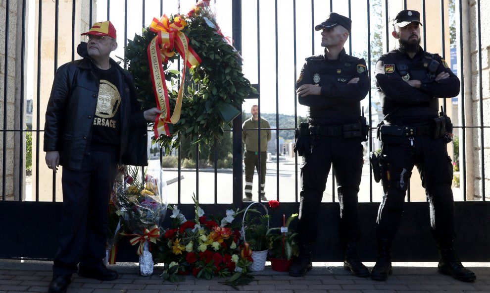 Un partidario del dictador español Francisco Franco se encuentra junto a agentes de policía en las afueras del cementerio Mingorrubio-El Pardo después del entierro de sus restos. REUTERS / Sergio Pérez.