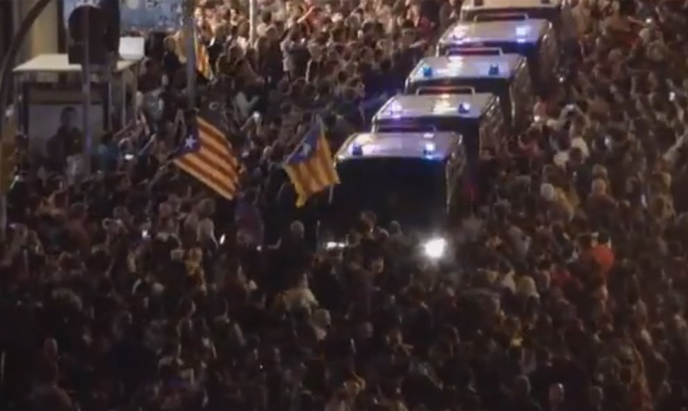 Furgones policiales se abren paso entre los manifestantes concretados en Via Laietana, en Barcelona.- CAPTURA