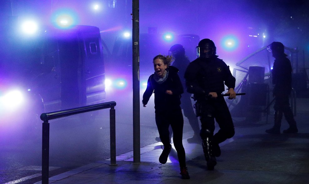 Una manifestante corre huyendo de las cargas policiales en Barcelona.- REUTERS / ALBERT GEA