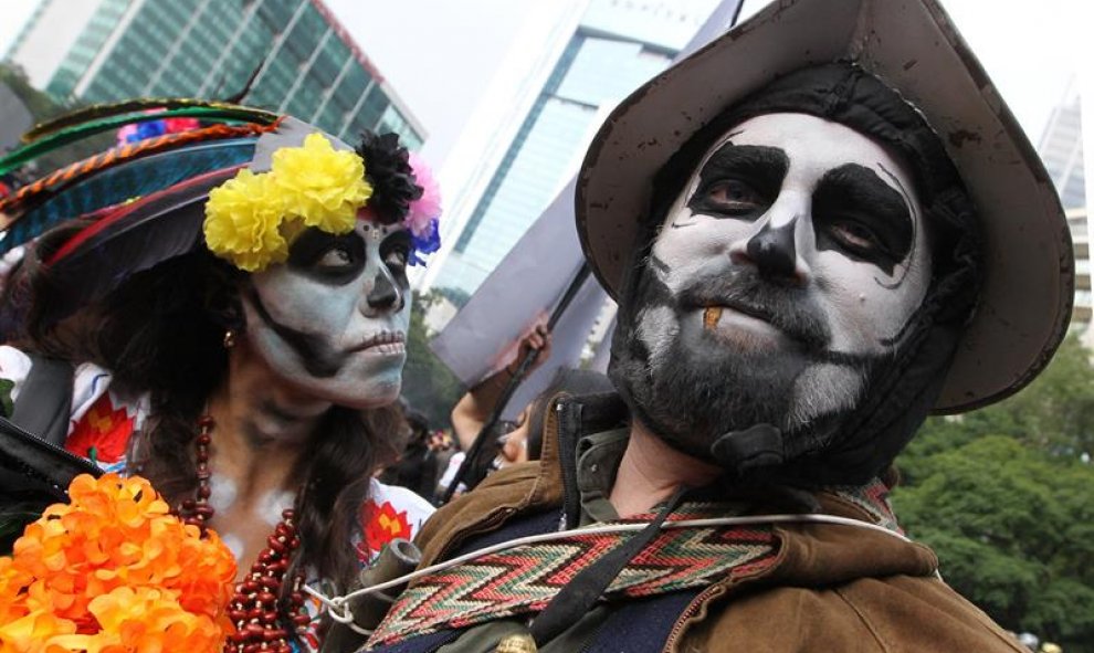 A lo largo del céntrico Paseo de la Reforma, decenas de agrupaciones culturales, regionales o de barrios de la capital caminaron, bailaron y cantaron con elaborados maquillajes y coloridos vestidos en representación de la muerte. EFE/ Mario Guzmán