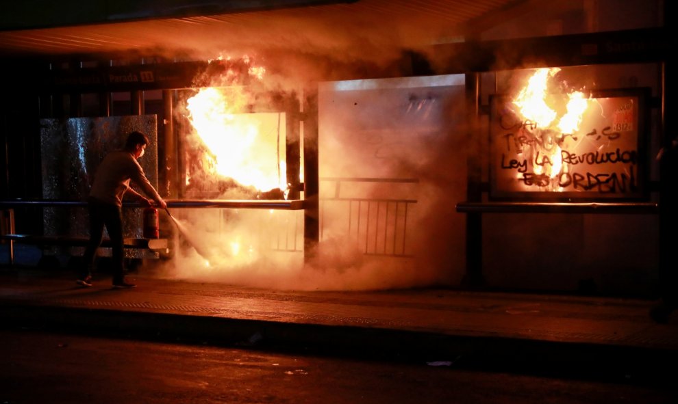 Un hombre extingue el fuego durante una protesta contra el gobierno en Santiago, Chile. REUTERS / Henry Romero