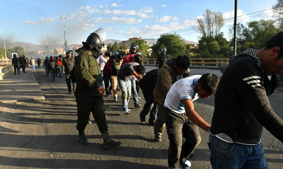 5/11/2019.- Policías bolivianos custodian a los detenidos luego de los choques con grupos de manifestantes este viernes, en Cochabamba (Bolivia).
