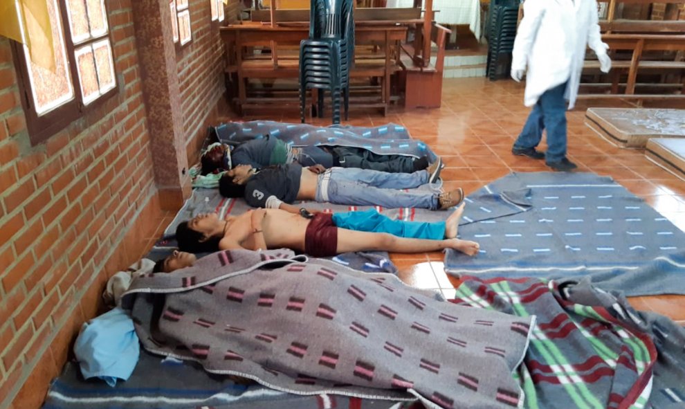 Un médico observa los cuerpos de cinco personas asesinadas durante los enfrentamientos entre la policía antidisturbios boliviana y los partidarios del ex presidente boliviano Evo Morales durante una protesta contra el gobierno interino en Sacaba, provinci