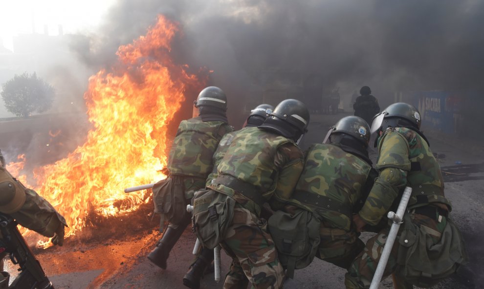 Miembros de la policía militar intentan destruir una barricada en Sacaba, en las afueras de Cochabamba, el pasado viernes, cuando se registraron graves disturbios entre cocaleros y fuerzas de seguridad en una marcha hacia Cochabamba contra el gobierno int