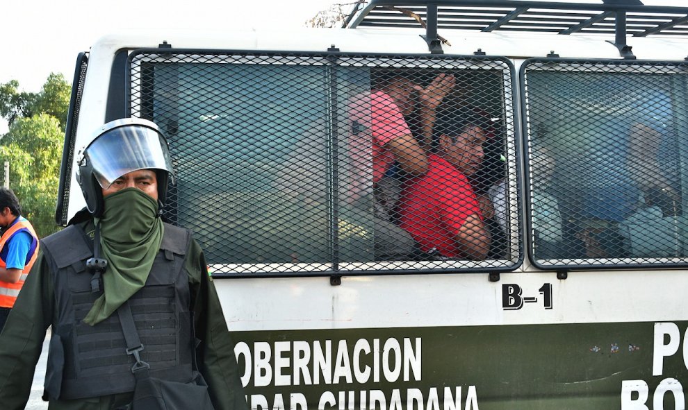 Varios detenidos permanecen en un vehículo de la policía tras los choques entre las Fuerzas Armadas y grupos de manifestantes el viernes viernes, en Cochabamba (Bolivia). Al menos siete personas murieron, al parecer manifestantes de grupos cocaleros.- EFE