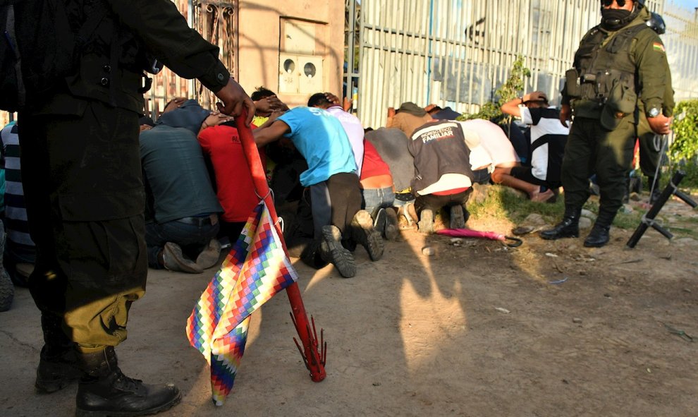 Policías bolivianos custodian a los detenidos después de los choques con grupos de manifestantes este viernes, en Cochabamba (Bolivia). Al menos siete personas murieron, al parecer manifestantes de grupos cocaleros, y 22 resultaron heridas durante disturb