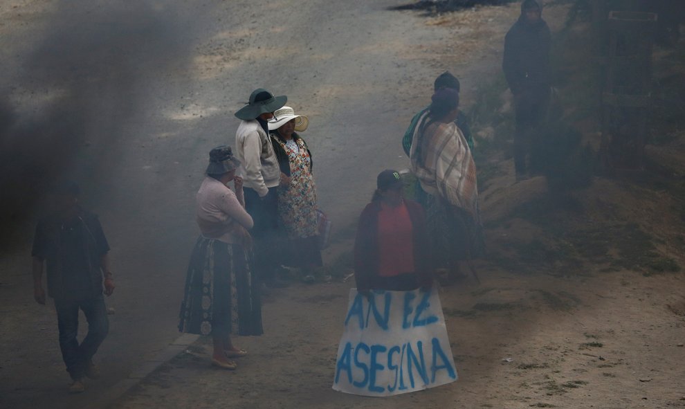 Una manifestante sostiene un pancarta en la que se lee "Añez asesina", acusando de las muertes en el Bolivia a la presidente interina del país, Jeanine, el pasado miércoles en Senkata, El Alto.- REUTERS/David Mercado