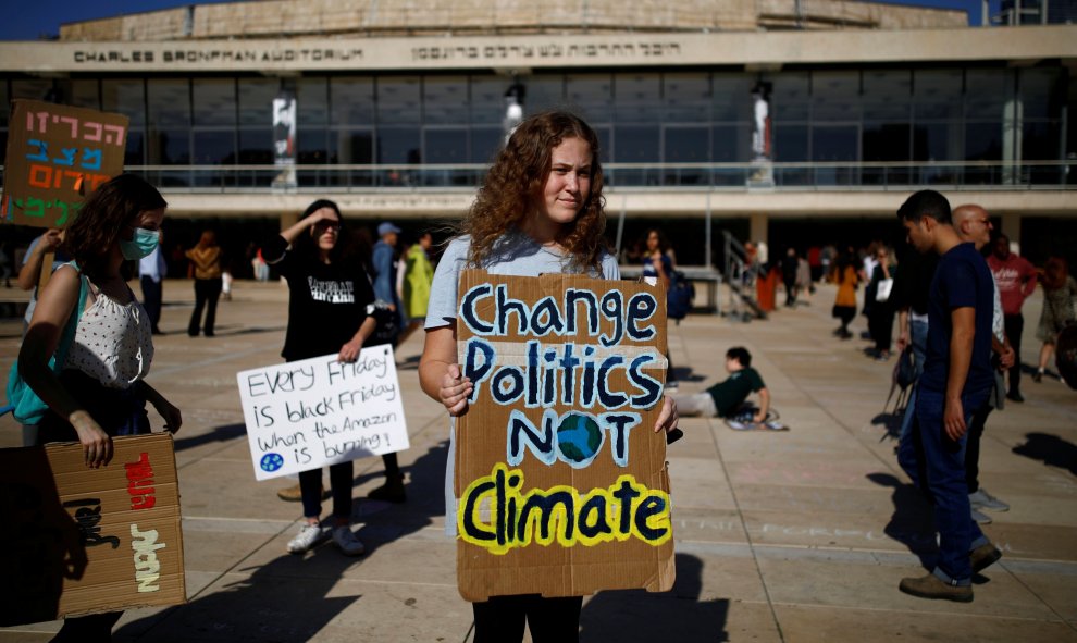 "Cambiad las políticas, no el clima" reivindica una manifestante israelí en su pancarta. / Reuters