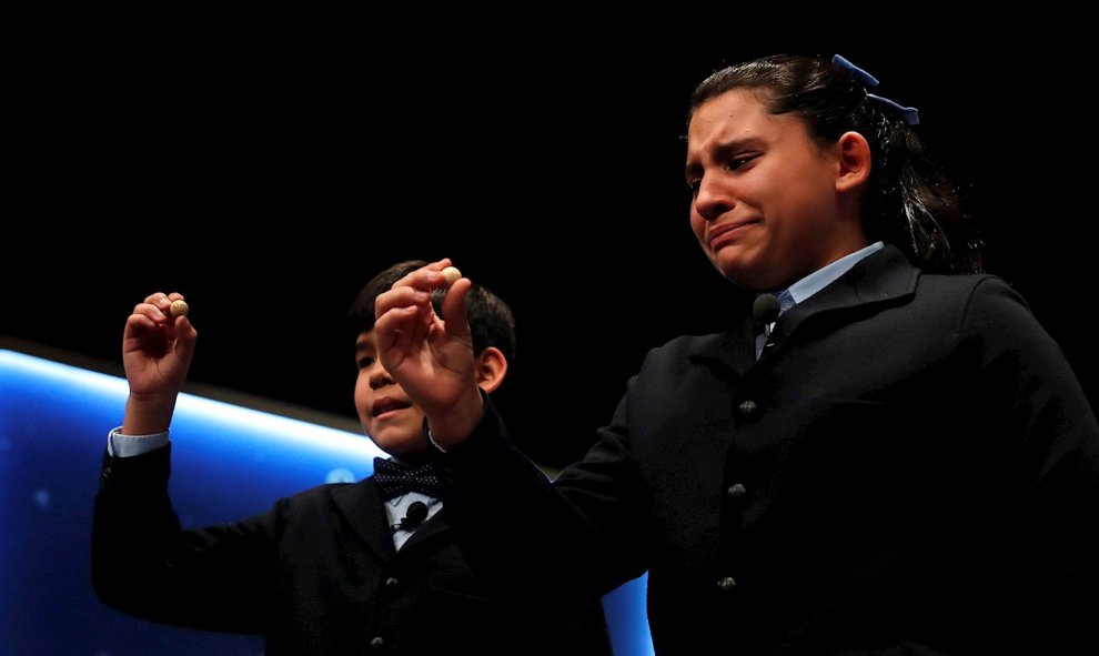 La niña Nerea Pareja, junto a su compañero Dávalos, ha cantado el primero de los quintos premios del Sorteo Extraordinario de la Lotería de Navidad que ha correspondido al número 75.206, se emociona al mostrar las bolas al público. EFE/Chema Moya