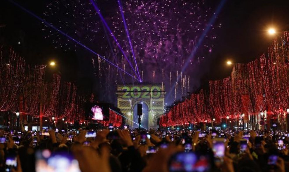 Miles de personas se congregan frente al arco del triunfo en París para celebrar la entrada del año. (Christophe Ena / AP)