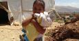 Niña siria refugiada en Líbano sostiene una 'muñeca' hecha con un trozo de madera / ACNUR